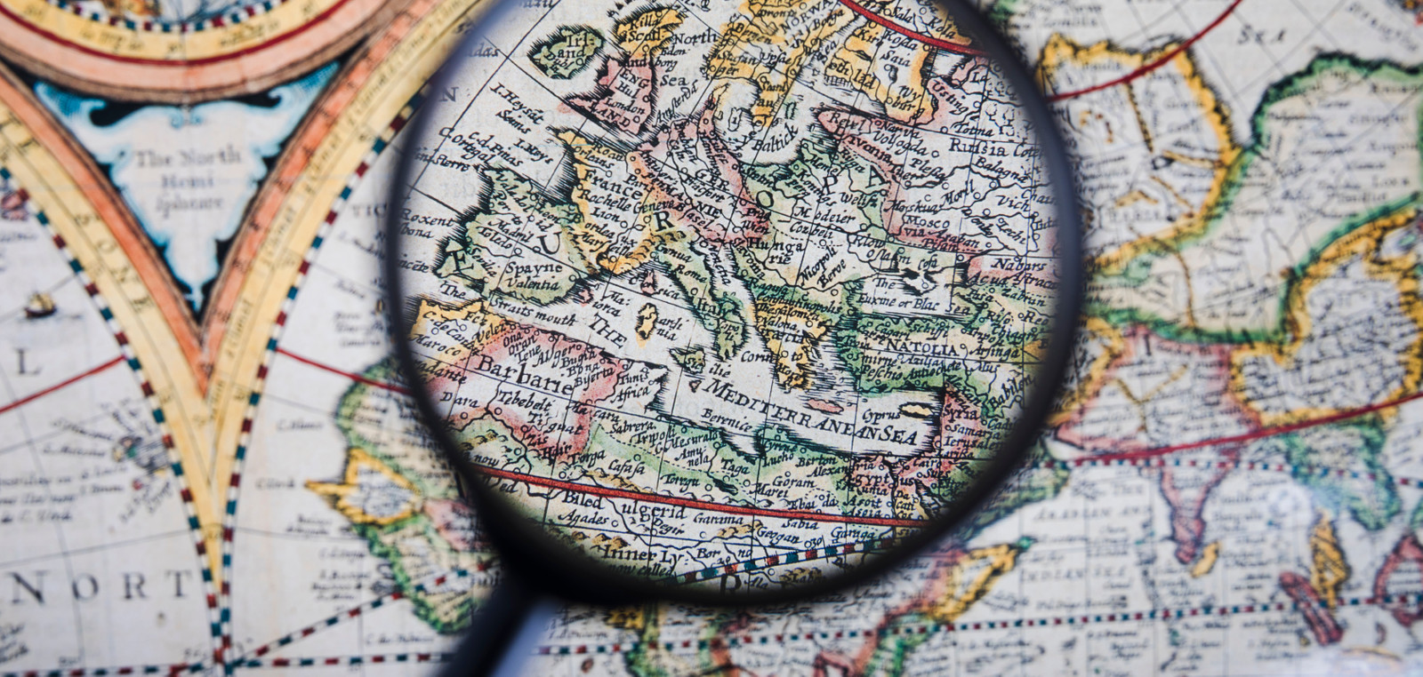 Close up magnifying glass colorful ancient map