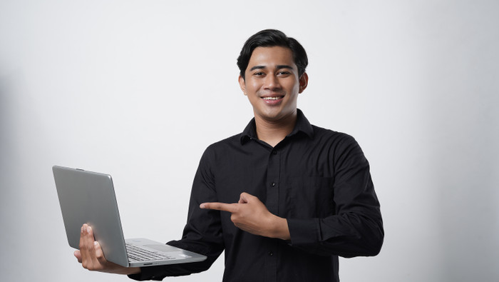 Portrait smiling asian young asian man black casual shirt pointing finger computer laptop